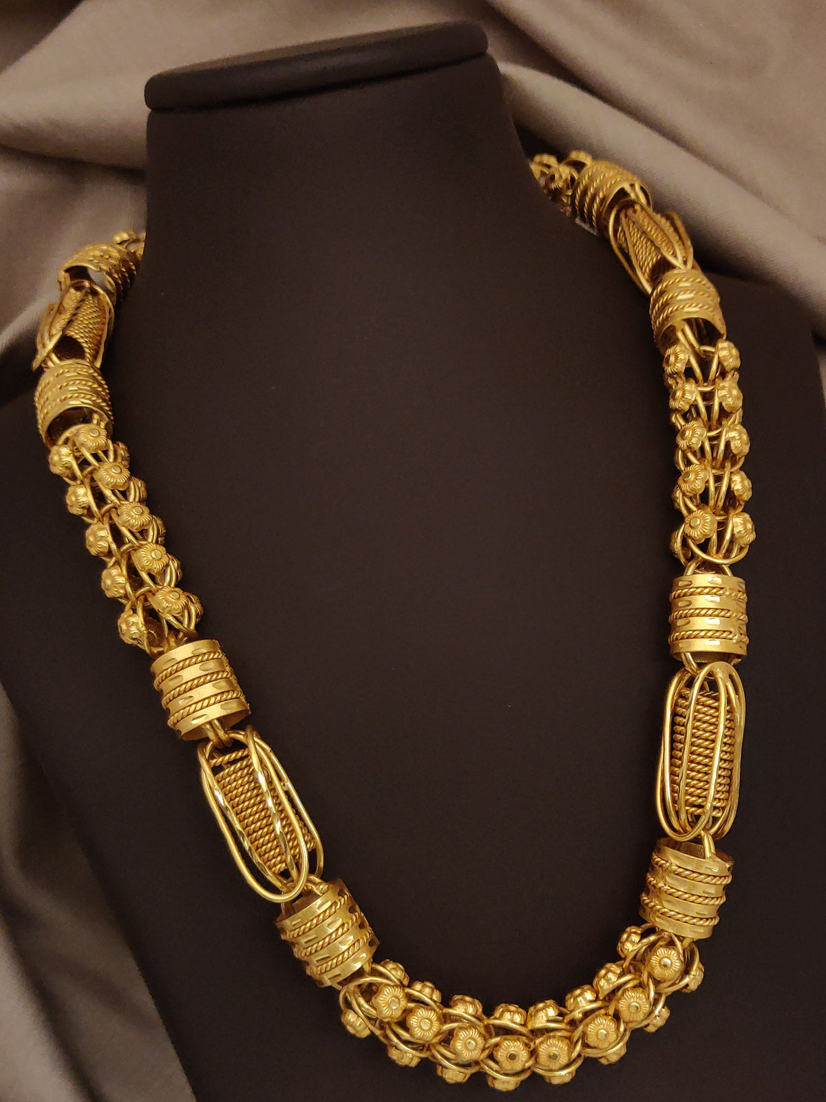 Gold necklace on a dark background with 'Haj Harshiv' branding.