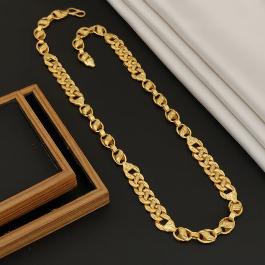Gold chain necklace on a dark surface with 'HARSHIV' branding.
