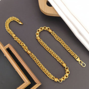 Gold chain necklace on a dark surface with 'HARSHIV' branding.