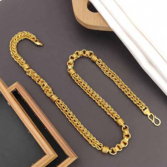 Gold chain necklace on a dark surface with 'HARSHIV' branding.