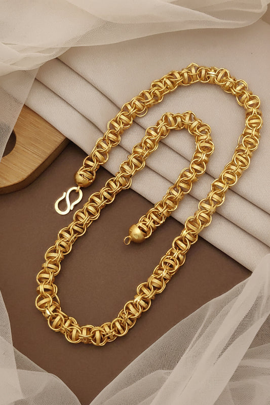 Gold chain necklace on a soft fabric background with 'HARSHIV' branding.